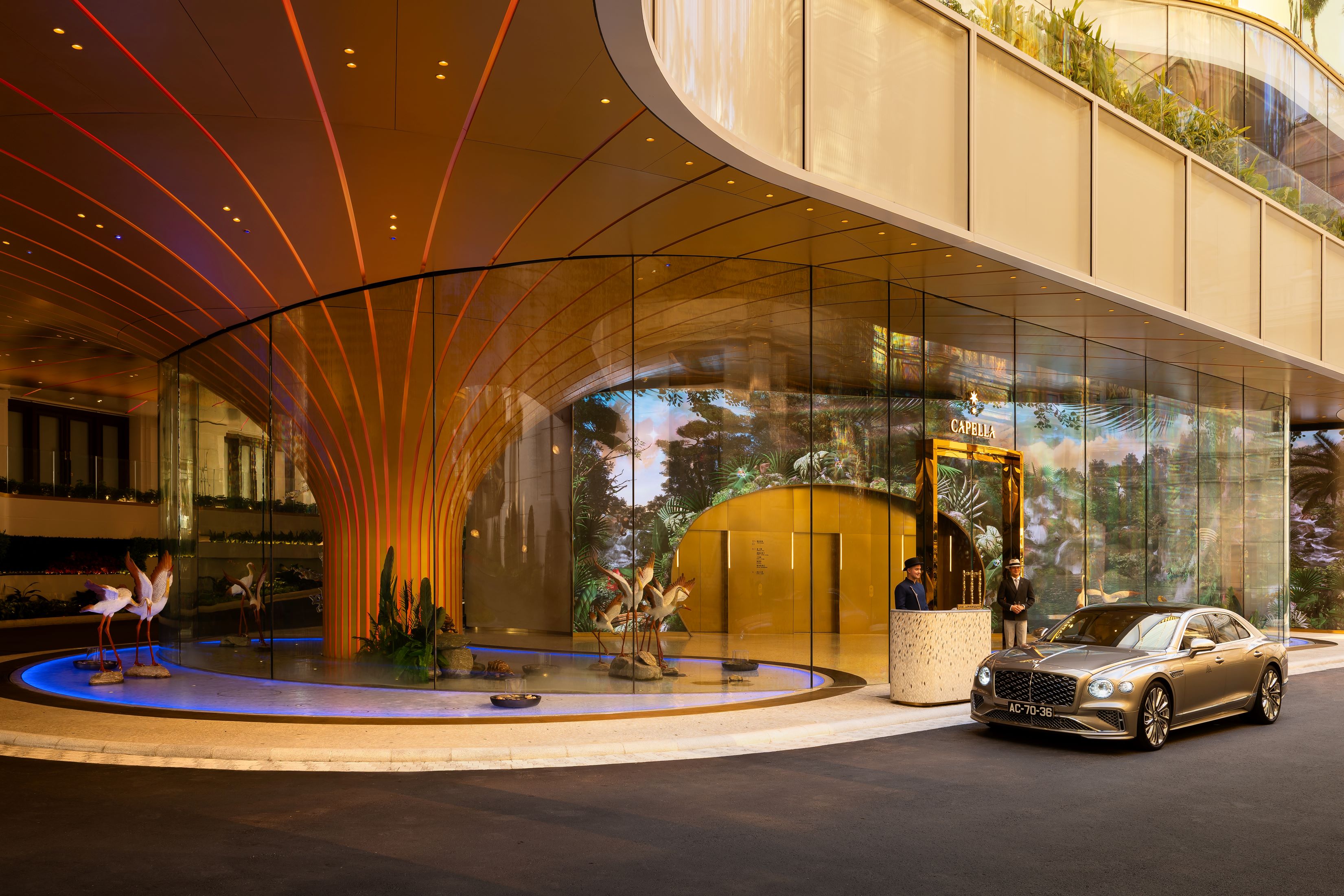 Gentle curves, softened edges, and dappled light that mimics sunlight filtering through a rainforest canopy guides guests from the moment they enter the driveway.