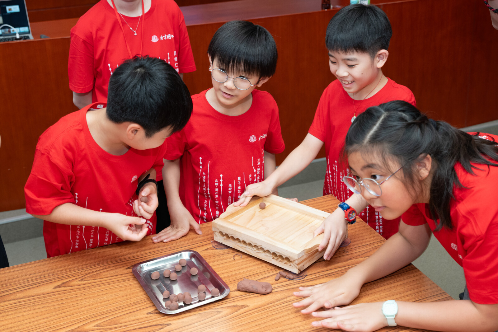学生于北京同仁堂工作坊亲手使用搓药板制作传统药丸,从实作中体验中药制剂工艺的细致要求,感受传统制药技艺的匠心精神。